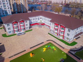 School near the lake with a playground. Aerial view