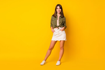 Photo of charming young lady wear green shirt mini skirt footwear isolated vivid yellow color background - obrazy, fototapety, plakaty