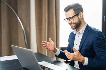 Slavic stylish man talking by video call, discussing work process, employer lead job interview with applicant laptop screen, businessman talk with client, communicating distantly use modern app