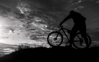 cyclist with a bicycle, on the black background .