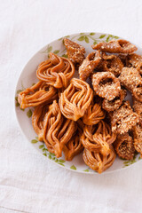 Vertical top view clean food shot of a plate with chebakia and almond sweets traditional from Morocco for Ramadan and Eid celebrations made of natural honey and first quality almonds and handcrafted.