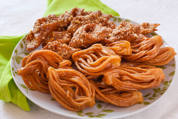 Ramadan delicious sweets typical from Morocco: Chebakia and almond pastries with green napkin and white linens background.