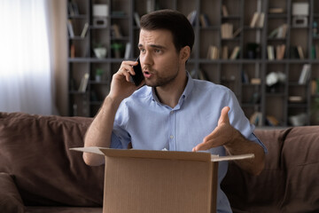 Unhappy angry Caucasian male client or buyer talk with customer service on cellphone frustrated by...