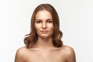Fototapeta premium Beautiful tanned brunette girl on a gray background