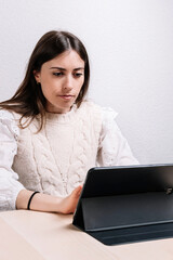 Young woman using a tablet while working at home. Entrepreneur concept. Young woman. Work at home concept.	
