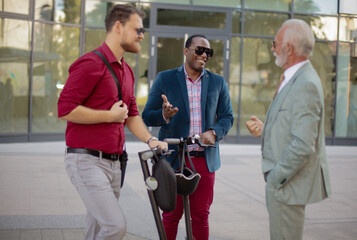 Smiling Diverse Partners Talking Outdoors. Three business colleagues standing outdoors and discussing.