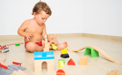 Child making structures with wooden toys.