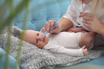 Runny nose in an infant.
Mom picks up a runny nose with an aspirator. Baby care.