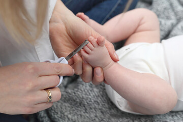 Obraz na płótnie Canvas Cutting baby's nails. Baby care, mom cuts her nails.