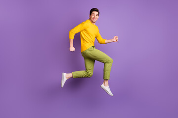Fototapeta na wymiar Full size profile side photo of young handsome happy positive man running in air isolated on purple color background