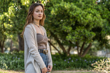Obraz premium Caucasian pretty young woman in a public park with background of trees