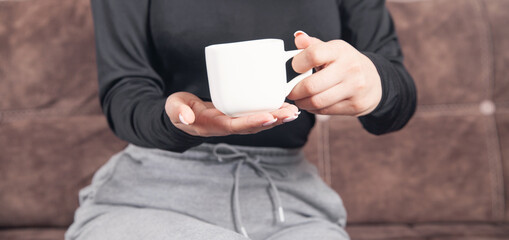 Young woman with a coffee cup at home.
