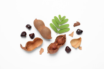 Delicious ripe tamarinds and leaves on white background, flat lay