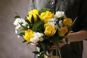 Woman with bouquet of beautiful peony tulips on beige background, closeup
