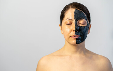 Woman relaxing with black charcoal facial mask