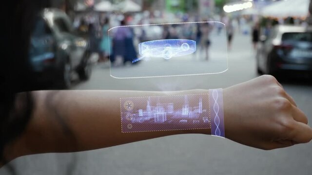 Female hand activates conceptual HUD holograms on smart bracelet with robotic vacuum cleaner. Unrecognizable woman with holographic technology on a city street background