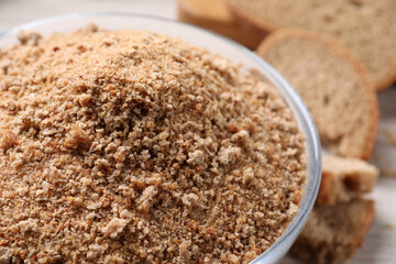 Fresh breadcrumbs in bowl on table, closeup