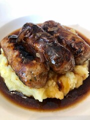 Traditional british dish, sausage and mash potatoes with onion gravy