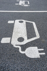 Parkplatz für Elektrofahrzeuge, E-Autos, Elektroautos mit weißem Symbol zum Aufladen,...
