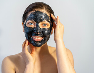 Woman relaxing with black charcoal facial mask