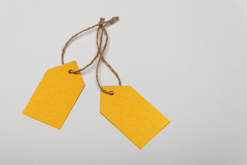 Yellow blank clothing tags, white background. Labels blank mockup