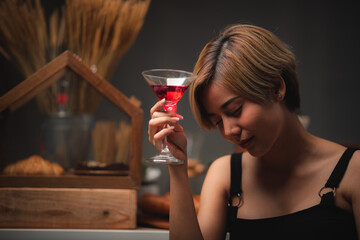 Attractive bartender girl holding in her hands fresh cocktail at the bar counter for celebration