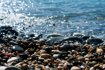 Beach stones and sea water in sunlight