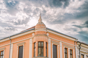 Orange building with dome and cloudy sky