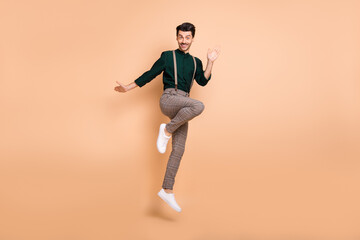 Fototapeta na wymiar Full body photo of funky attractive young man jump up air good mood isolated on pastel beige color background