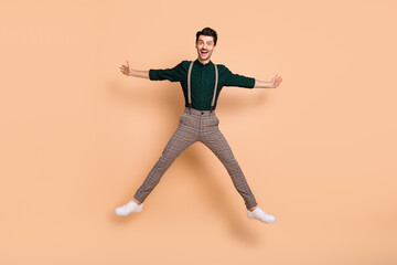 Fototapeta na wymiar Full body photo of young excited man happy positive smile have fun jump up isolated over beige color background