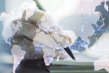 Double exposure of abstract digital world map and woman hand writing in notepad on background, big data and blockchain concept