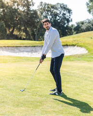Fototapeta premium A young Caucasian male playing golf on a professional golf course