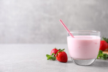 Delicious strawberry drink on light grey table. Space for text