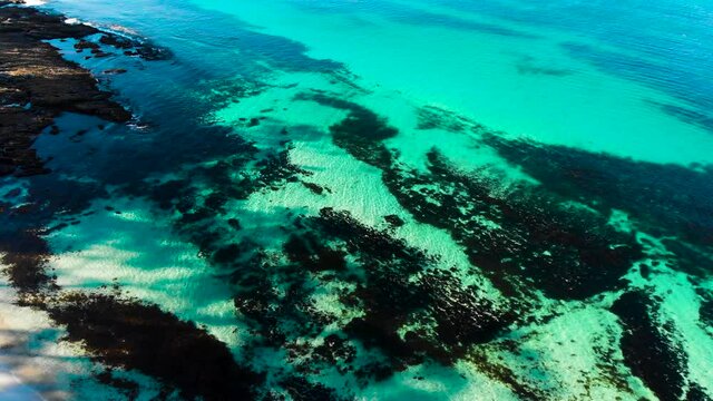 Drone Flying Down Towards Hyams Beach, Revealing The Turquoise Ocean With The Waves Crashing on The White Sandy Beach
