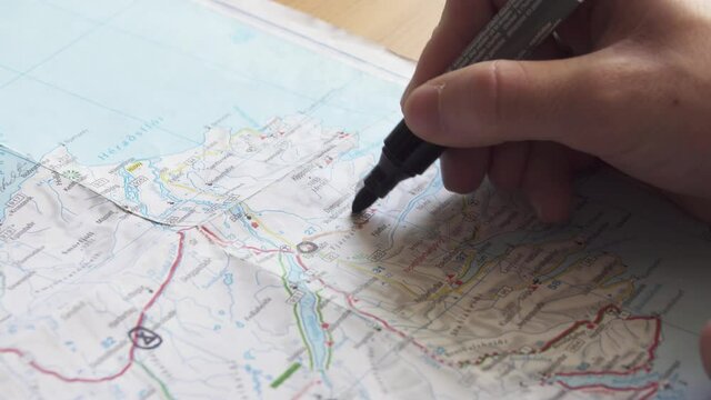 Closeup of a Edding marker drawing lines on a map while planning a roadtrip.
