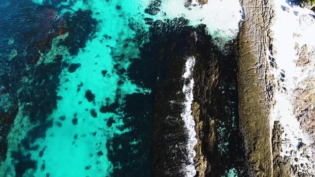 Straight Down Drone Shot Of Hyams Beach, Flying Over The Turquoise Ocean With Waves Crashing on the White Sandy Beach