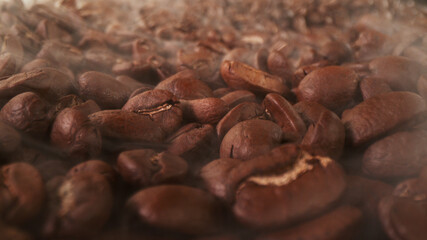 Pile of fresh roasted coffee beans with smoke around