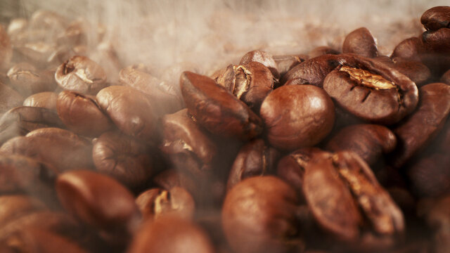 Pile of fresh roasted coffee beans with smoke around © Jag_cz