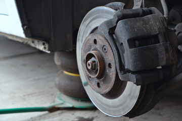 Car repair. Car on jacks without wheels. Close-up view of brake discs.
