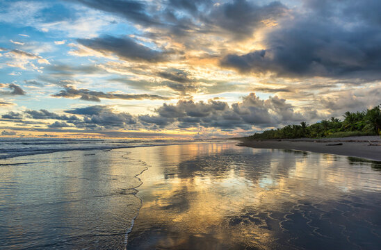 Beautiful sunset sky with clouds on the beach in Matapalo, Costa Rica. Central America. Sky background on sunset. Tropical sea.