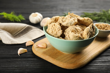 Dried soy meat in bowl on black wooden table