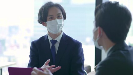マスクをつけコロナウイルス対策をし会議するビジネスマンたち - Powered by Adobe
