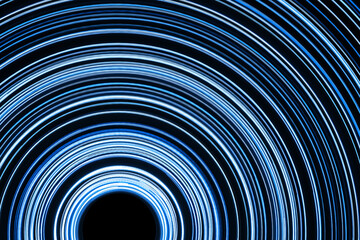 Blue circular lines. Futuristic design. Abstract neon circle lines with empty copy space inside isolated on black background. Colorful led lights long exposure rotation photo. Neon ring texture.