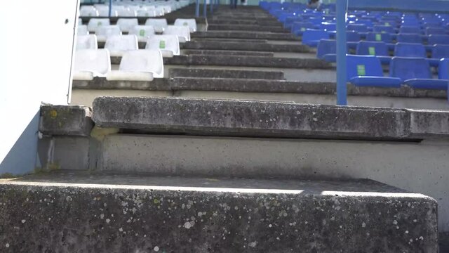 Plano subiendo las escaleras de piedra de unas gradas de un campo de futbol