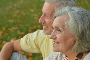 Portrait of beautiful senior couple sitting on grass
