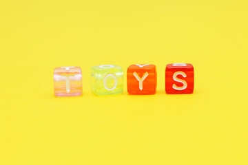 Word toys with colorful cubes of beads on yellow