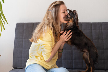 Obraz premium Happy blonde woman kiss embrace funny brown russian toy terrier 