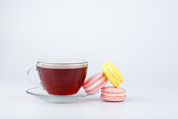 Cup of tea and colorful macaroons on a white background.