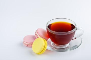 Cup of tea and colorful macaroons on a white background.