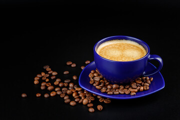 Cup of coffee and coffee beans on a platter on a black background
